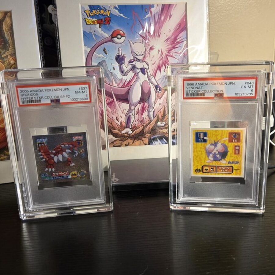 Two PSA graded vintage Amada Pokemon sticker cards displayed in Podium acrylic cases